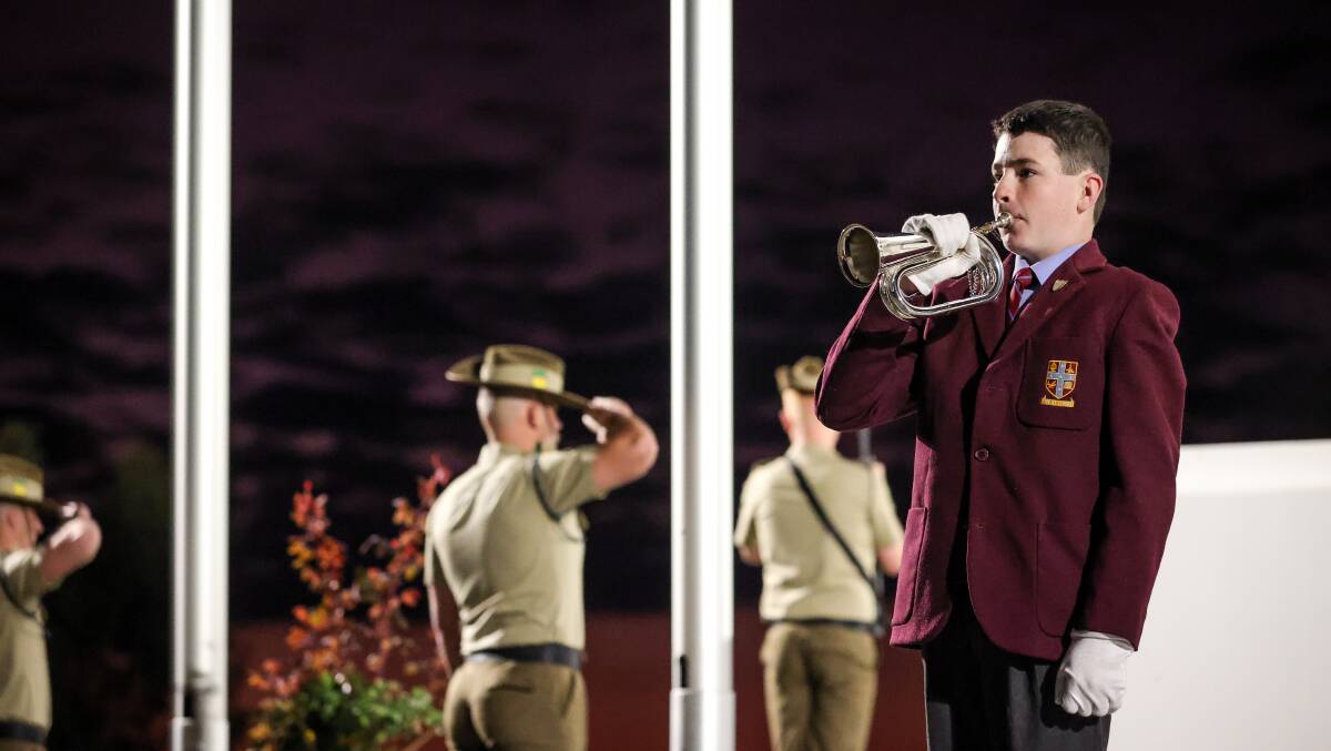 Bugler Billy Stewart sounds The Last Post as the sky starts to lighten at the dawn service. Picture by James Wiltshire