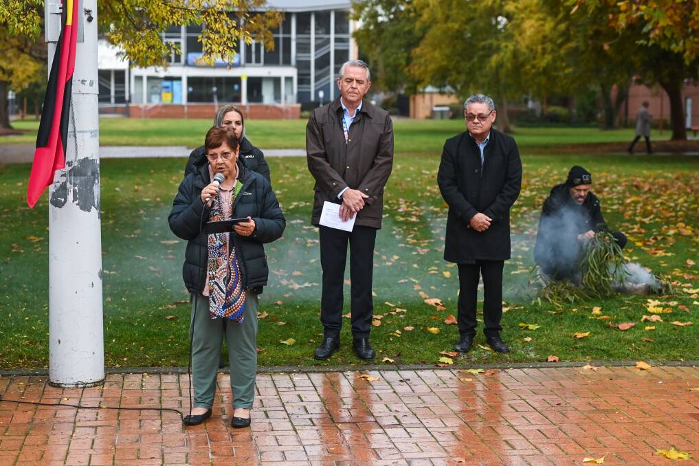 Aunty Edna Stewart welcomes onlookers to Wiradjuri country before the QEII Square flag-raising. Albury Council's chief executive Frank Zaknich and Aboriginal community development officer Mark Dodd watch on. Picture by Mark Jesser