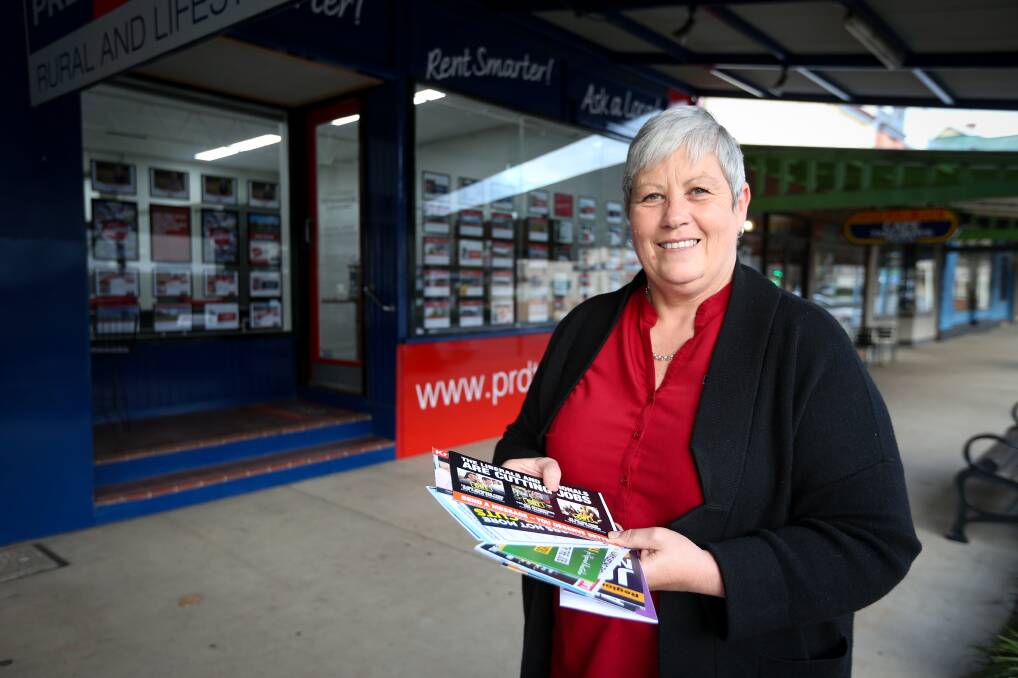 Bombarded: Tumbarumba estate agent Julie Giddings with an array of election pamphlets which have been aimed at voters in her area. A record 14 candidates are standing for the poll. Picture: JAMES WILTSHIRE