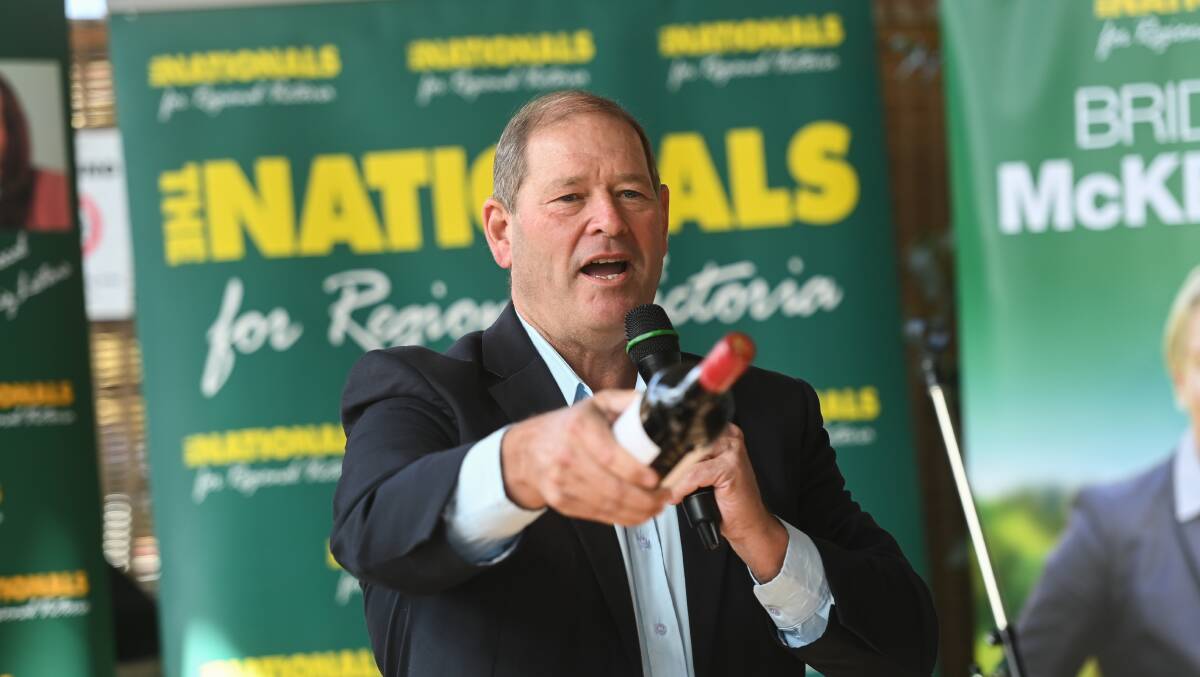 Rolling with it: MP turned auctioneer Tim McCurdy seeks bids on a bottle of wine at the Nationals campaign launch.