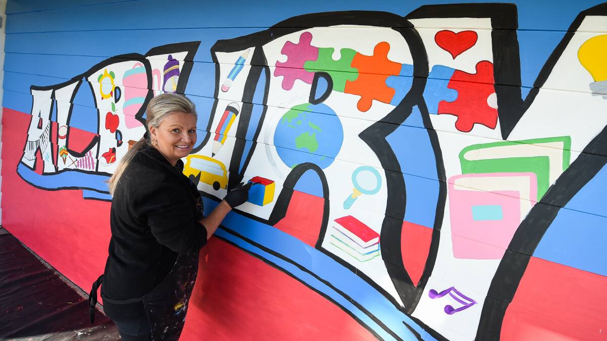 Dabbing: Sharee Richardson adds some paint to a block that features in the R that is part of the word Albury in the school mural. Picture: MARK JESSER