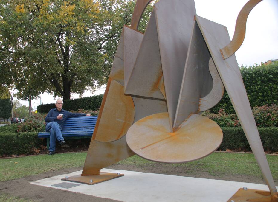 Pleasing: Sculptor Ken Raff was pleased to take a seat and eye off his artwork at its new base near the Caltex service station on the corner of Dean and Creek streets in Albury.