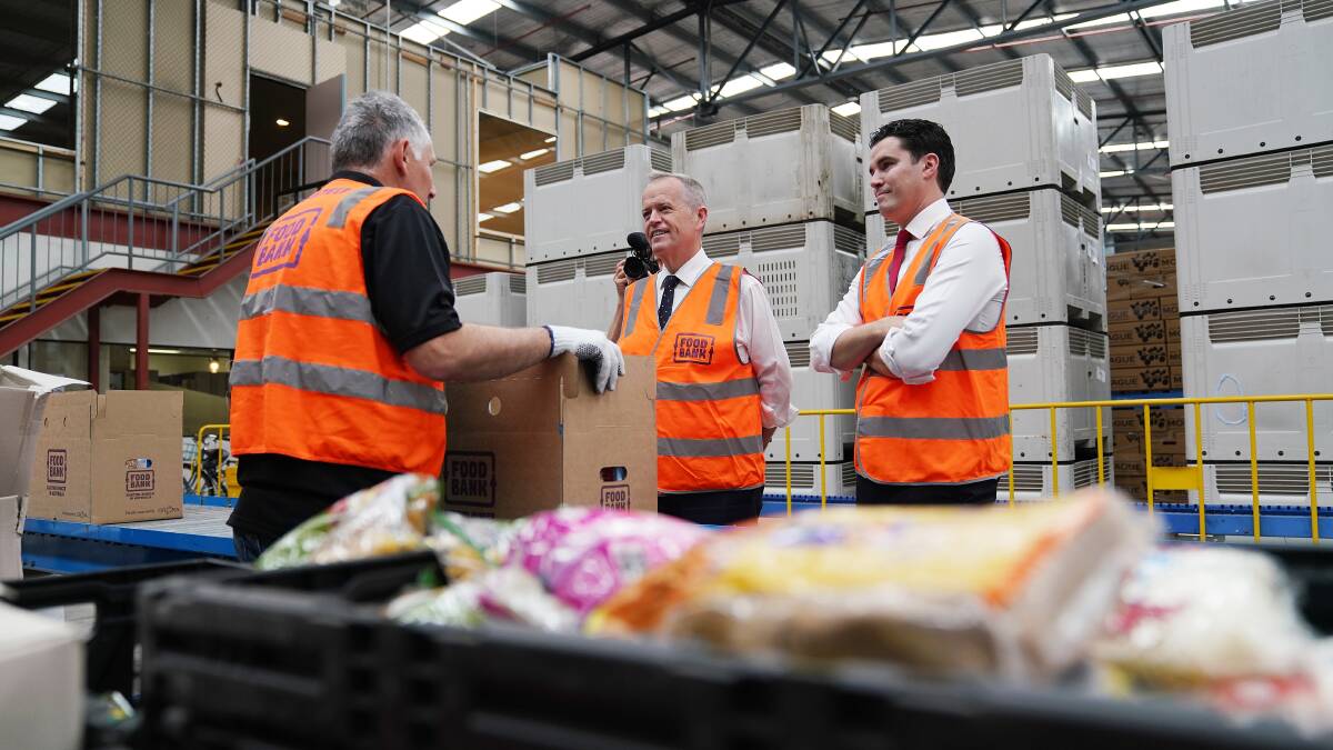 On tour: Opposition Leader Bill Shorten (centre) speaks to a Foodbank packer in Melbourne on Monday.
