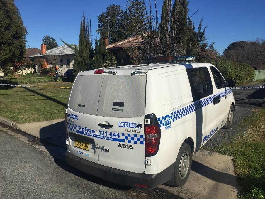 Taped off: A police van outside the exclusion area set up around the house gutted by fire in Kestrel Street in North Albury.