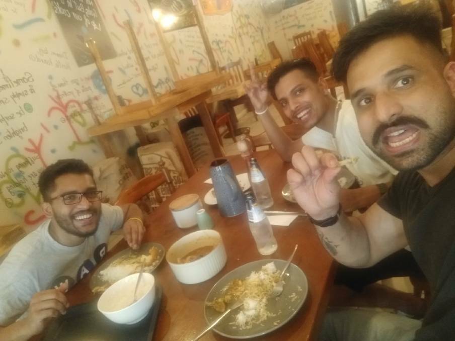 Tinged with tragedy: Bigul Pandit (middle) with friends Emamul Milon and Guru Ghuman enjoying a meal just hours before he vanished.