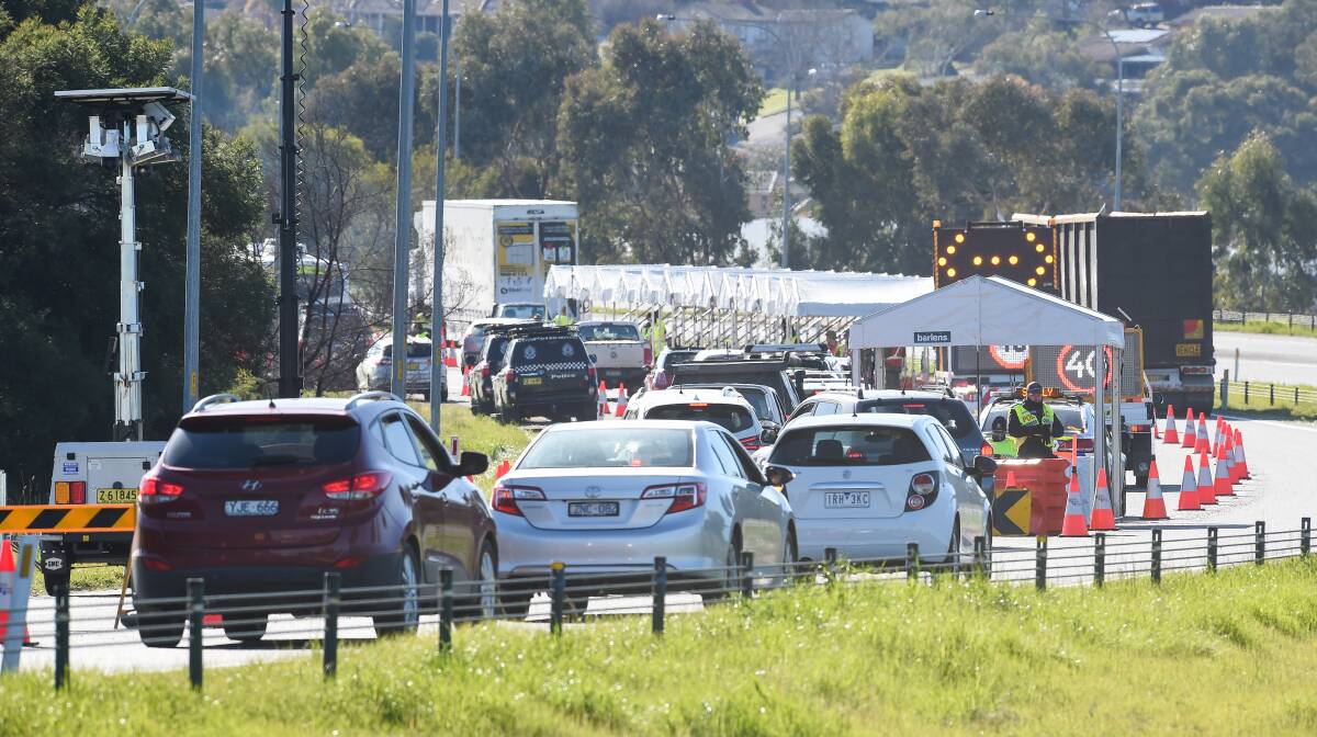 Line up: Motorists wait to be checked at the Hume Freeway checkpoint in Albury on Tuesday. As of Wednesday they will need a new permit to enter NSW. Picture: MARK JESSER