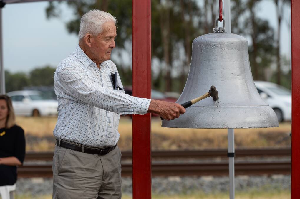 Sad sound: Violet Town firefighter Ian Chanter hit the town's fire bell after the names of each victim was uttered at Thursday's vigil at the crash site. Picture: MARK JESSER