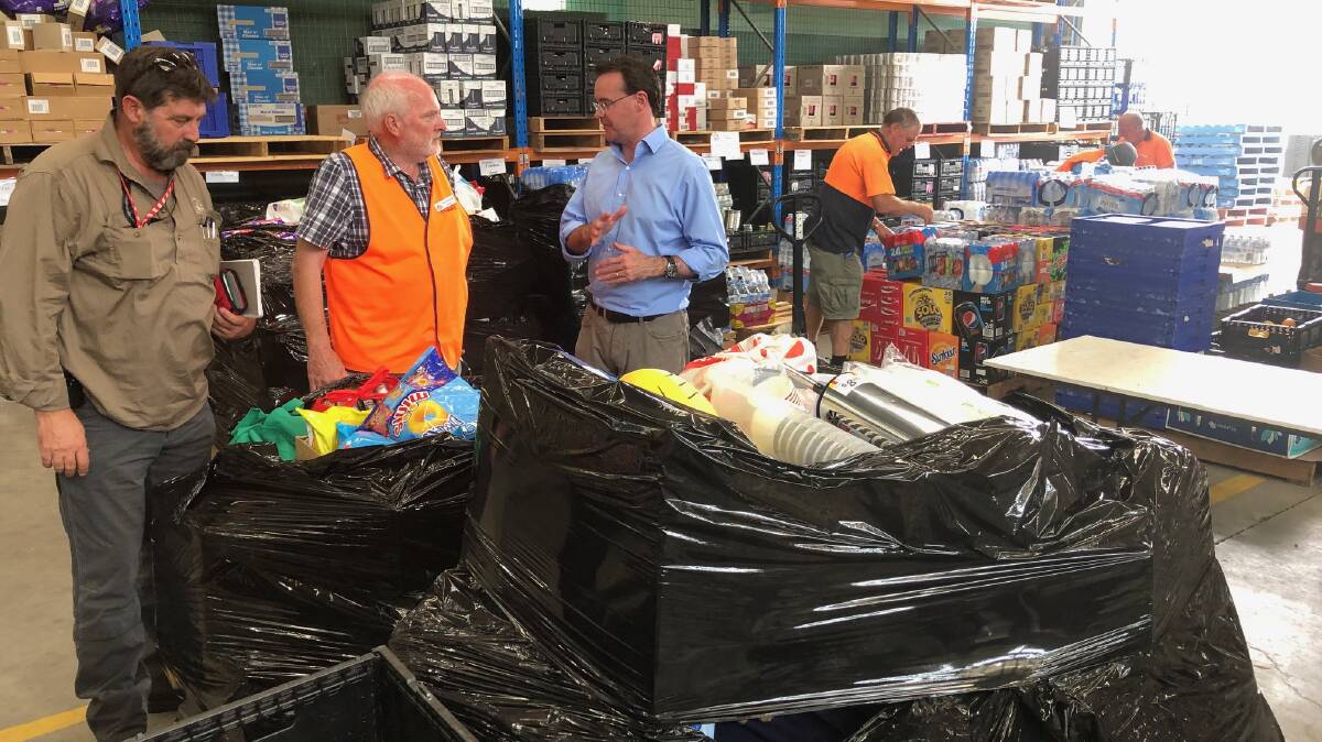 Donations piled up: Member for Benambra Bill Tilley with Albury Wodonga Regional FoodShare manager Peter Matthews and Victorian Opposition leader Michael O'Brien at the charity's shed in west Wodonga where goods to help the victims of the Upper Murray fires have been massed and distributed to the needy.