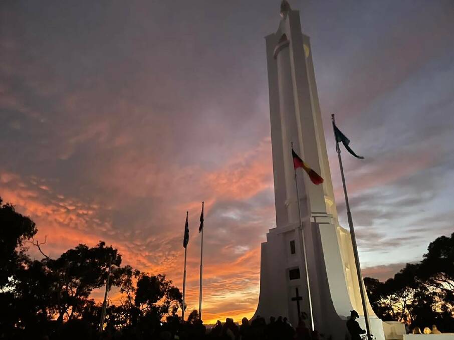 Sun rises: The scene at the conclusion of the dawn service at Monument Hill with flags fully raised.