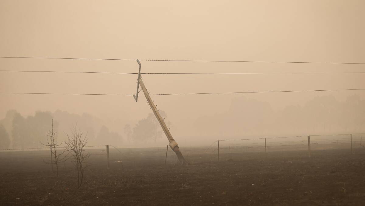 One among many: A power pole near Corryong left askew after being damaged by fire. Picture: JAMES WILTSHIRE