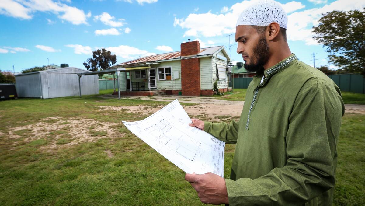 Flashback: Then Islamic Society of Albury Wodonga president Yakub Mohammed in 2016 with plans for a custom-designed mosque to replace the weatherboard home in the background that was used for worship.