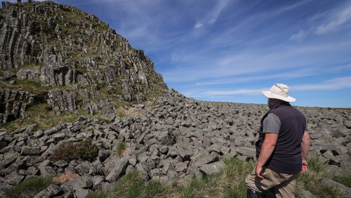 Wildlife biologist Dean Heinze walking across a boulder field on Mount Loch. Picture by James Wiltshire 