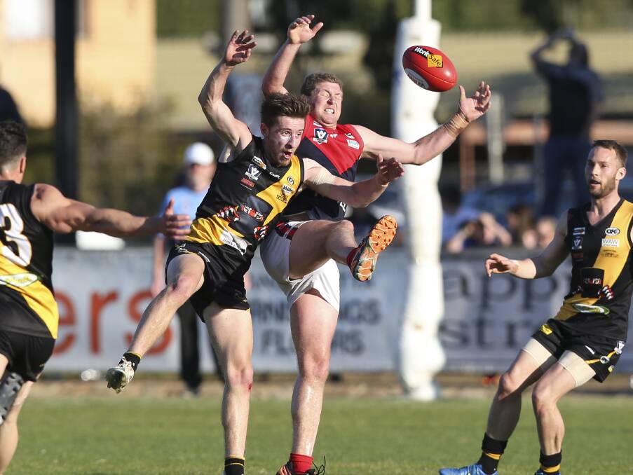SURROUNDED BY TIGERS: Milawa's Ray Ussher plays a lone hand for the Demons in Saturday's Ovens and King grand final against Glenrowan.