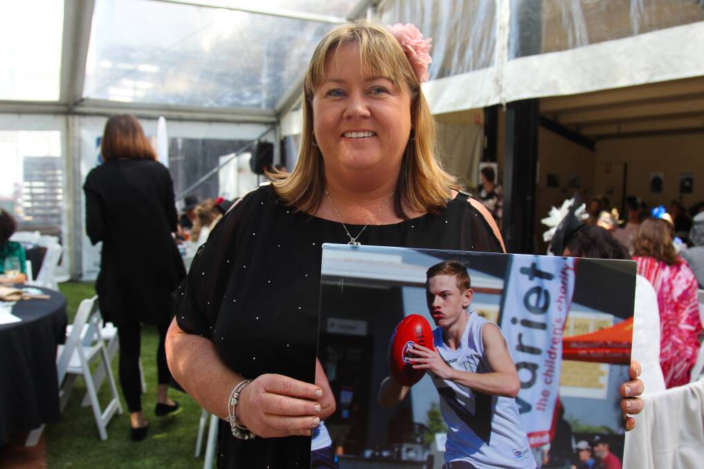 Katrina Redcliffe with a photo of her son Jarrod. Aspire grants have helped Jarrod thrive at football. 