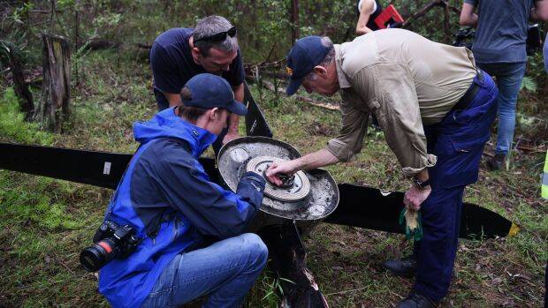 ATSB investigators and police examine the propeller that fell off an aircraft on approach to Sydney Airport. Photo: Nick Moir