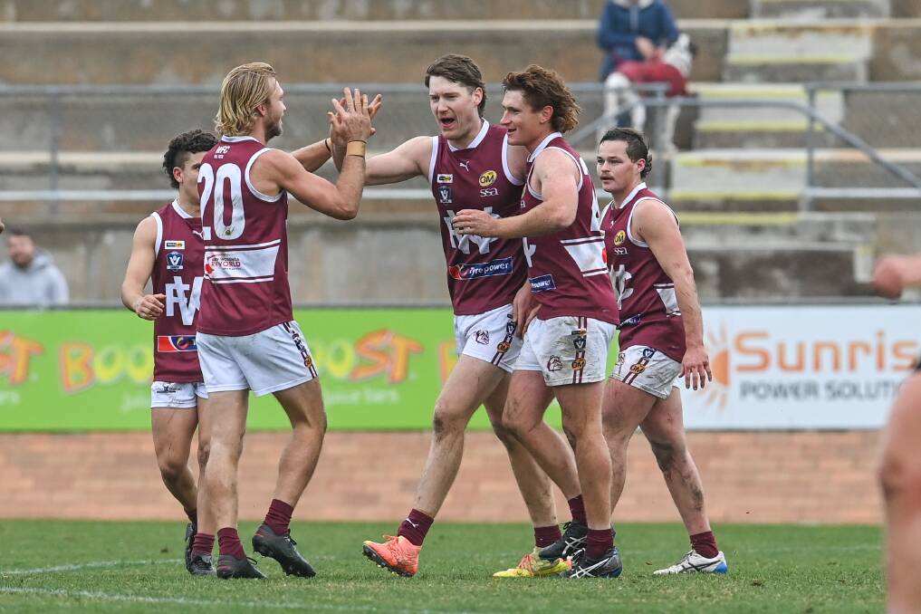 CENTRE OF THE ACTION: Wodonga's Hudson Garoni (middle) is congratulated after kicking one of his seven goals against Lavington. Picture: MARK JESSER