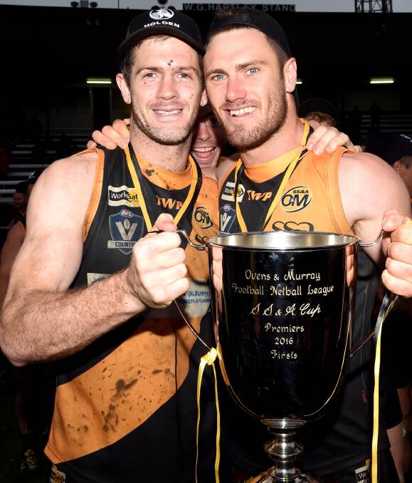 Albury co-coach Shaun Daly and midfielder Brayden O'Hara celebrate with the premiership cup after last month's 40-point win over Lavington at the Lavington Oval.