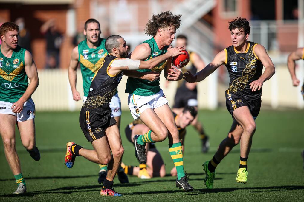 North Albury's Julian Hayes is tackled by Albury's Jeff Garlett
in the last round on July 10.
