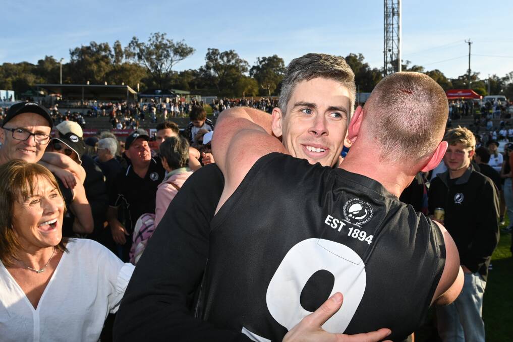 Sidelined Wangaratta defender Jamie Anderson is hugged by team-mate and good friend Callum Moore after the Pies' thrilling grand final win over Yarrawonga.