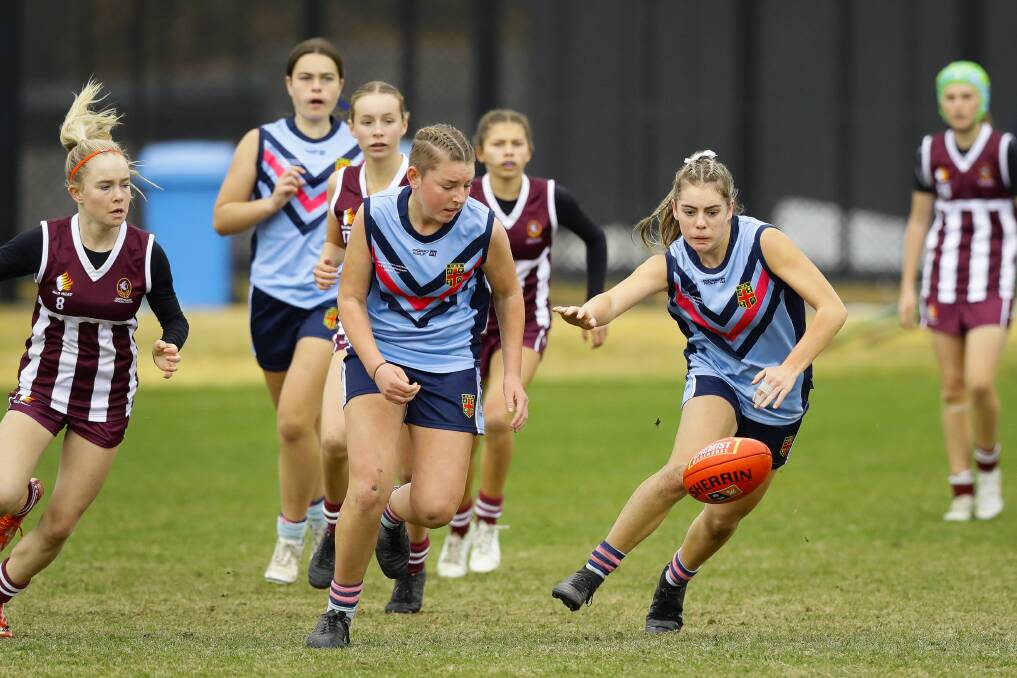 North Albury Xavier High School students Rose Bell (centre) and Molly McLaren look to win possession for NSW in its match against Queensland. Picture: ASH SMITH