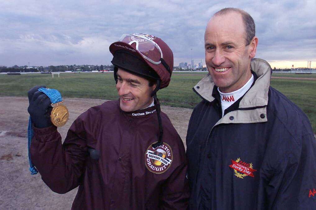 Former leading jockey Darren Beadman (left) admires Andrew Hoy's 2000 Olympic gold medal, just after the Sydney Games.