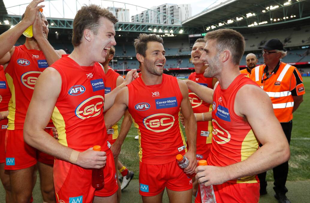 Anthony Miles (right) celebrates with Gold Coast Suns team-mates. Miles has now entered the coaching ranks at Albury.
