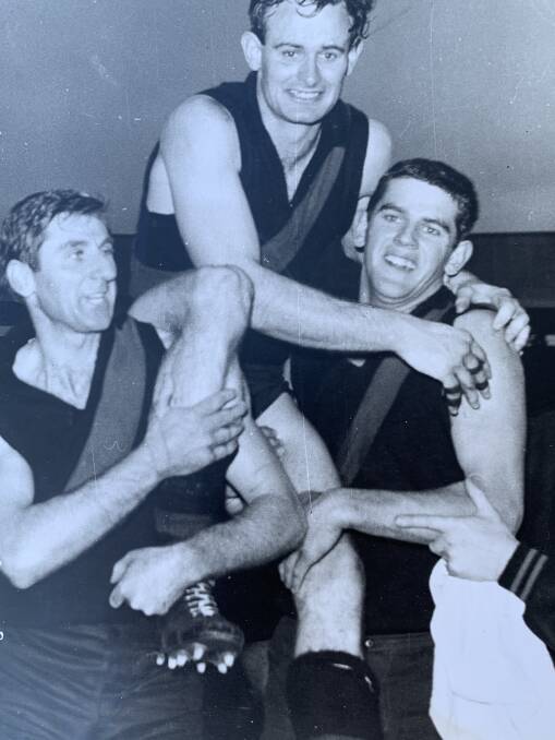 Essendon captain Ken Fraser is chaired off by team-mates Charlie Payne and Hugh Mitchell.after the 1965 grand final win over St Kilda.