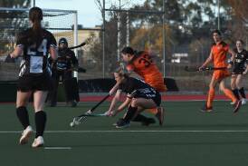 Magpies' Tahlia Rekunow (crouching) and Falcons' Kate Hughes battle for possession. Picture by Hockey Albury Wodonga