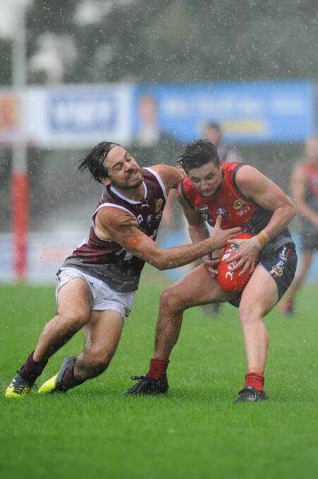GOT YOU: Wodonga's Tom Bowring tackles Raiders' Ash Van Klaveren in the rain which fell during the middle stages of the game at Birallee Park. Pictures: MARK JESSER