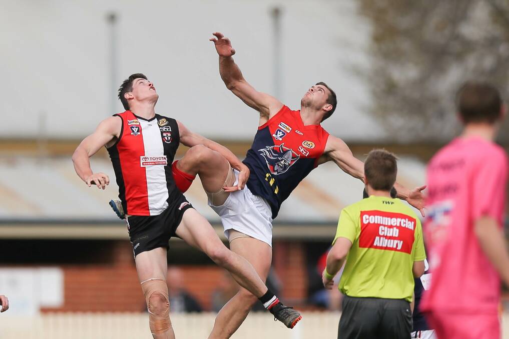 TOUGH GIG: Makeshift Myrtleford ruckman Ryan Crisp (left) battles Raiders' Brodie A'Vard. The latter missed much of the second half with injury.