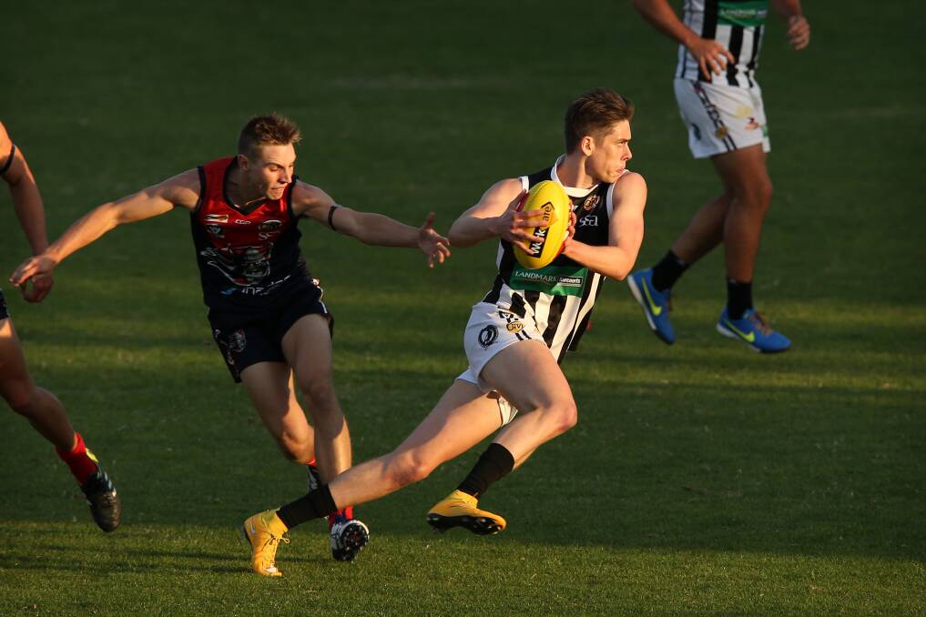 Wangaratta's Jamie Anderson (with ball) and Wodonga Raiders' Brad St John were rivals in this game, but they'll team up when the O and M hosts Western Region at Yarrawonga's JC Lowe Oval on Saturday.