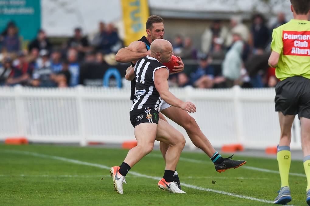 BIG COLLISION: Lavington coach Simon Curtis tries to beat Matt Kelly's tackle late in the final term. Both were terrific for their teams. Picture: MARK JESSER