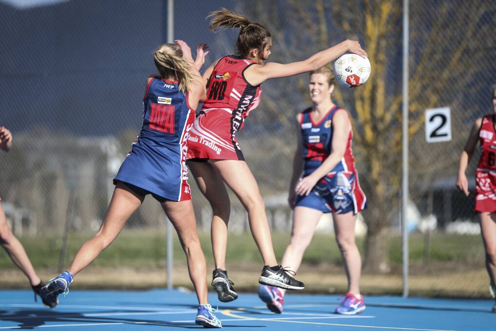 TOUGH WORK: Myrtleford's Sophie Cappellari is forced to work hard for her possession by Raiders' Lilly Smith in their thrilling battle.