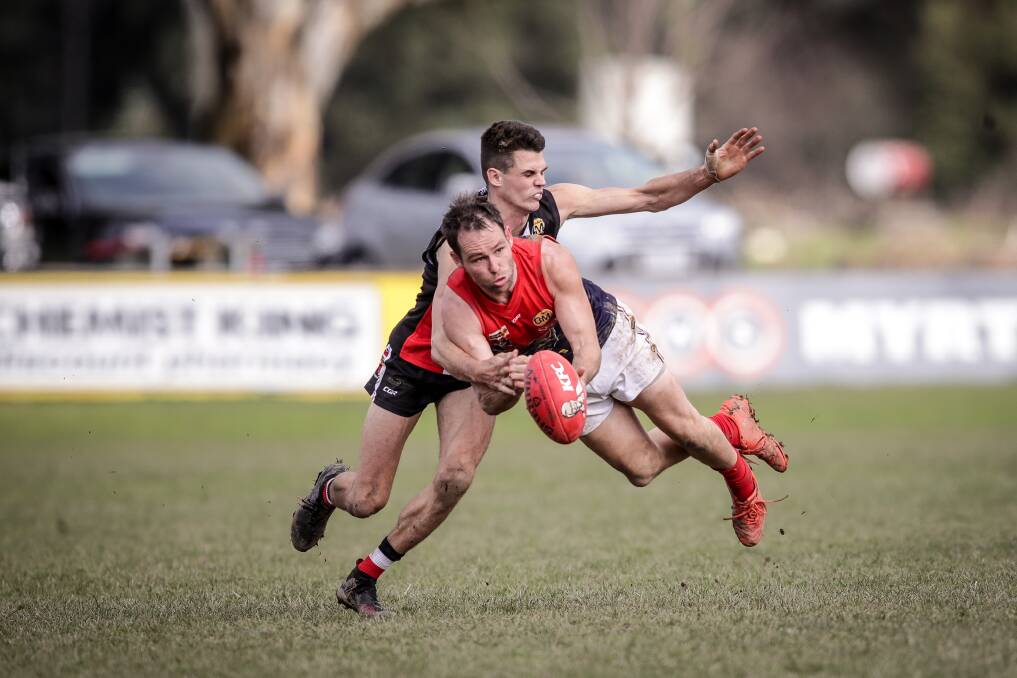 Wodonga Raiders' Morris medallist Jarrod Hodgkin (in mid-air) fires out a handball against Myrtleford in round 15. It was one of four straight best on grounds, while his cousin Alessandro Belci shared the under 18s medal.