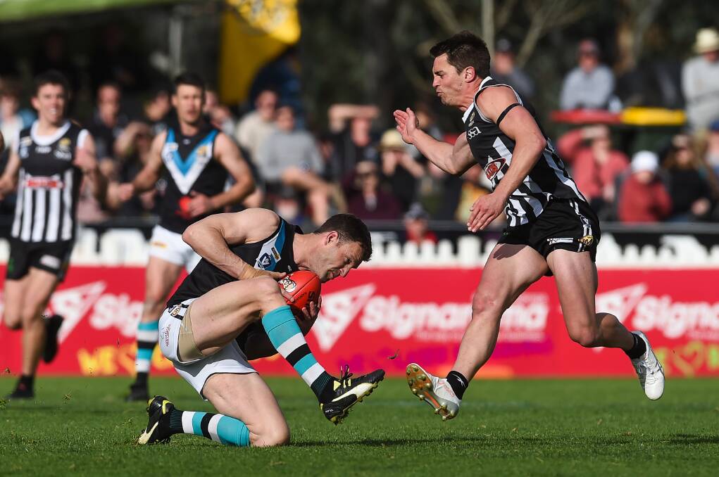 Lavington's Adam Butler (with ball) tries to evade Wangaratta's Ben Speight in last year's grand final. It's still unclear if there will be one this year.