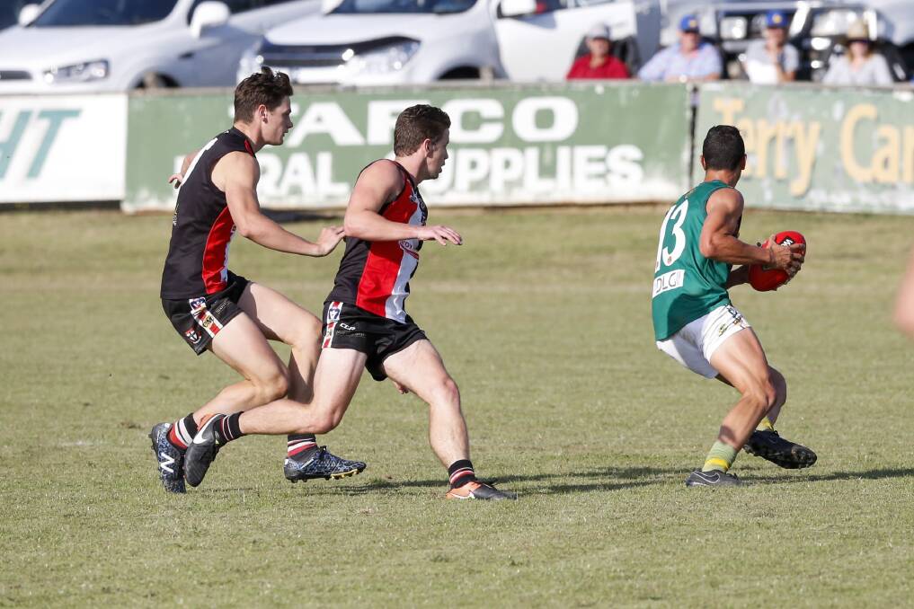 THIS WAY: North's Lachlan Taylor-Nugent leads his Saints' opponents a merry dance. Taylor-Nugent was one of the Hoppers' best, kicking three goals.