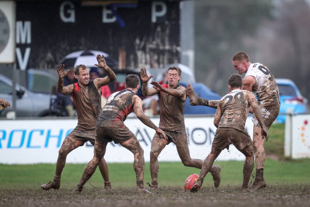 STRIKE ONE: Wangaratta's Callum Moore tries to kick the ball, but misses in the mud at Myrtleford's McNamara Reserve on Saturday. Picture: JAMES WILTSHIRE