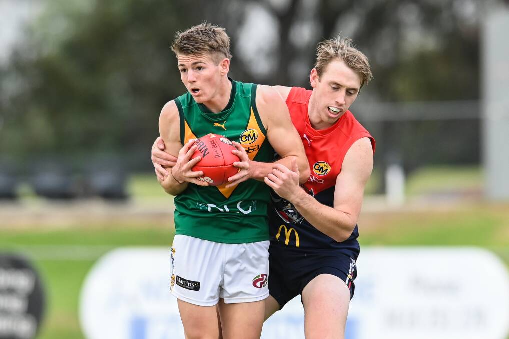WHAT A WIN: North Albury's Foster Gardiner is held by Wodonga Raiders' Will McCarty in Saturday's match. North upset the home club, snaring its first win since 2019. Picture: MARK JESSER