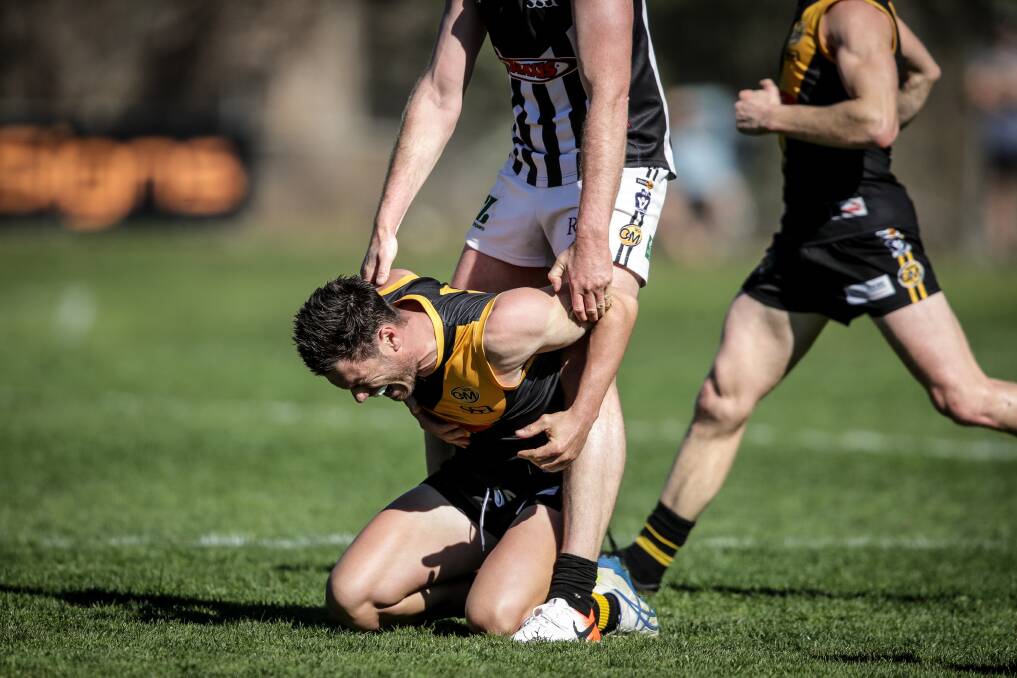 ON THEIR KNEES: Albury's Brayden O'Hara feels the effects after a collision with Wangaratta's Michael Newton, who, interestingly, held O'Hara up. Picture: JAMES WILTSHIRE