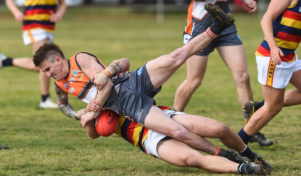 Giant Blake Lieschke is wrapped up in a strong tackle from Billabong Crow's Tyson Schofield at Walla on Saturday. Picture: MARK JESSER