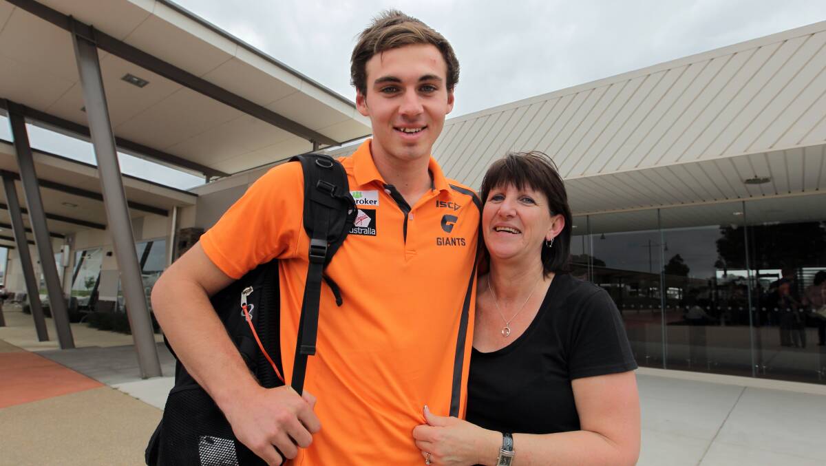 GIANT PUP: Jeremy Finlayson with his mum, Carol, at Albury airport after being selected to join the GWS academy in 2014. The Culcairn junior has played 48 matches with the fledgling club and faces Richmond in the biggest match of the season on Saturday.