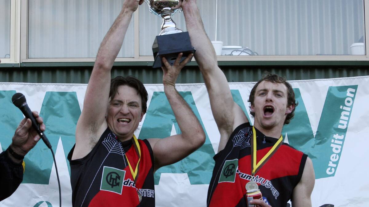 PREMIERS: Coach Marc Almond and skipper Troy Cooper hold the premiership cup aloft. The Spiders clinched the flag after launching a 10 goal blitz during the third quarter to capture their first flag since 2002.