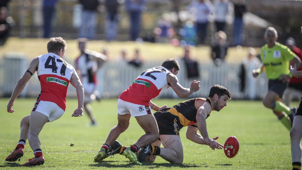 TOUGH TIGER: Albury's Joel Mackie disposes of the ball as Myrtleford's Malachi Owers closes in. Picture: JAMES WILTSHIRE