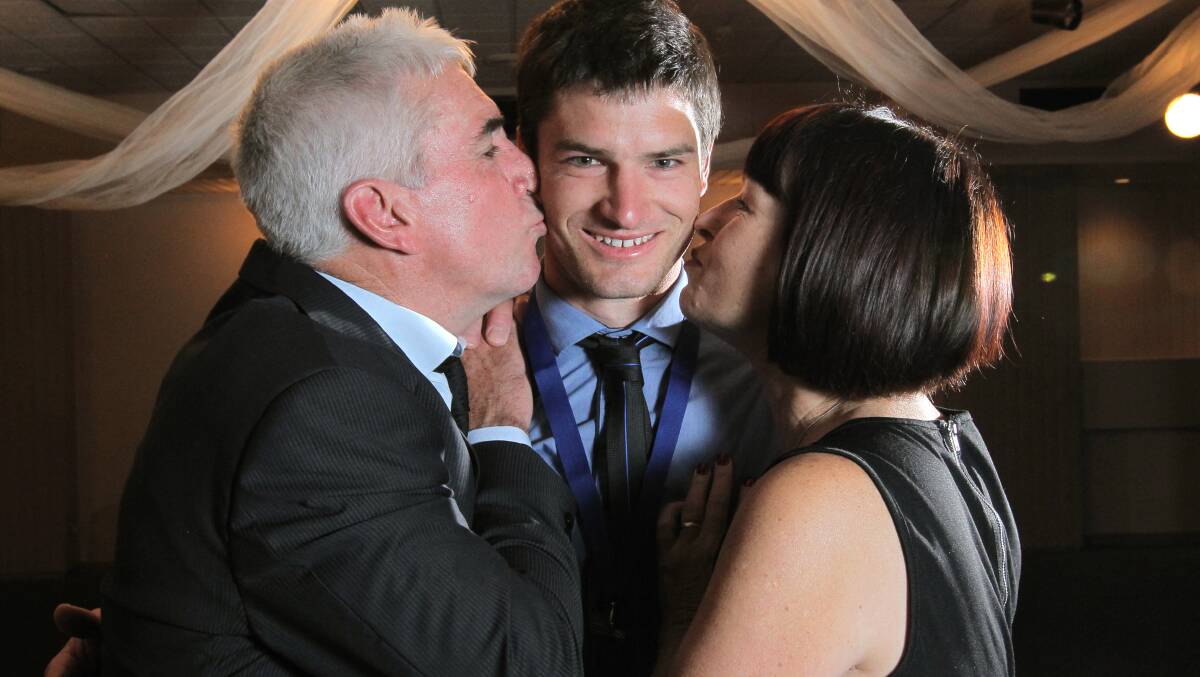 SEALED WITH A KISS: Mackie celebrates his Morris medal victory in 2012 with his parents Rob and Joy.