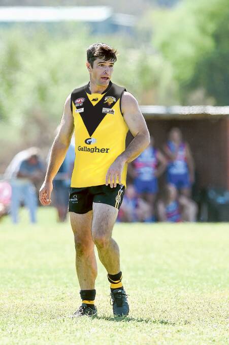 THE OSTRICHES: Osborne coach Joel Mackie with a digital image of the club's new jumper which is predominantly yellow with a black V.