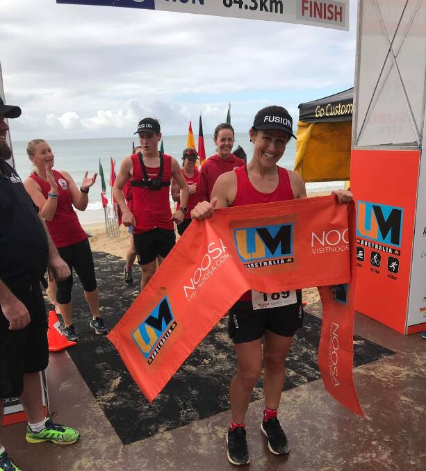 ULTRA IMPRESSIVE: Sarah Dare crosses the finish line on the final day of the Noosa Ultraman. Her support crew is in the background and were with her every step of the way during the gruelling event.