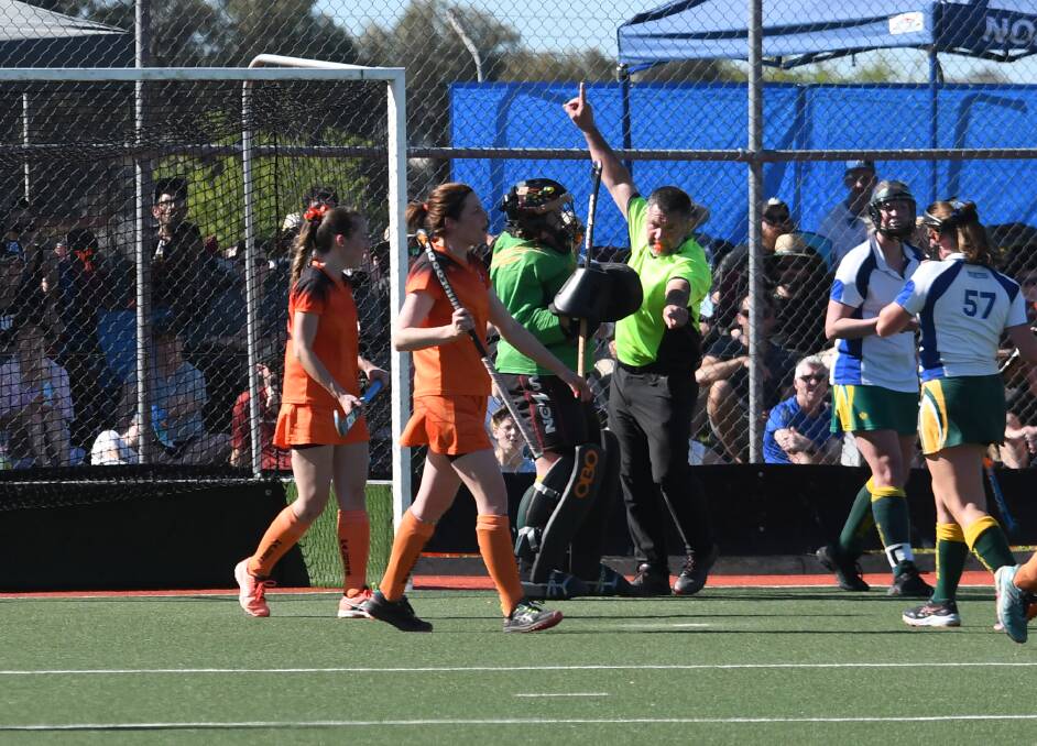 Umpire Tony Jones signalling a penalty stroke, which ultimately ended the nil-all deadlock in the division one women's grand final. Picture supplied
