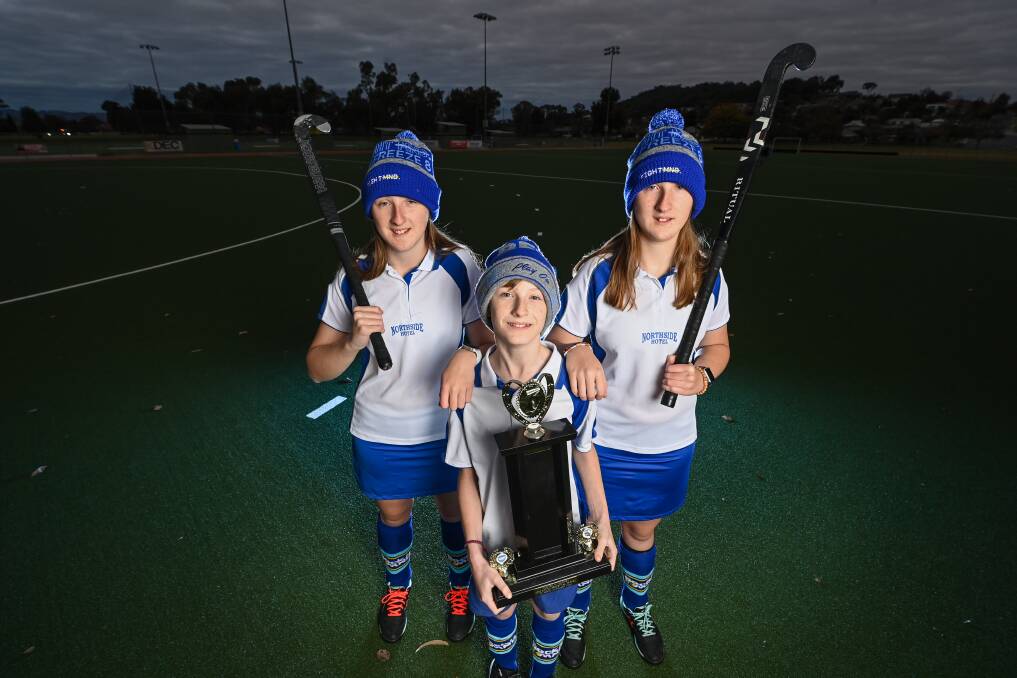 FITTING TRIBUTE: April, 13, Dexter, 11, and Adelaide Horne, 13, with the MND trophy to be played for in honour of their late grandmother, Margaret Caton. Picture: MARK JESSER