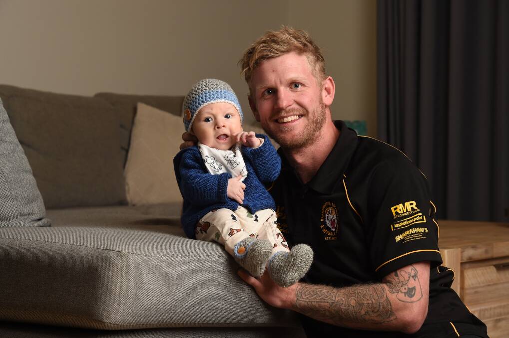 MAGIC MOMENT: Cam McNeill relaxes at home with son, River, ahead of his 200th match with Barnawartha on the weekend. Picture: MARK JESSER