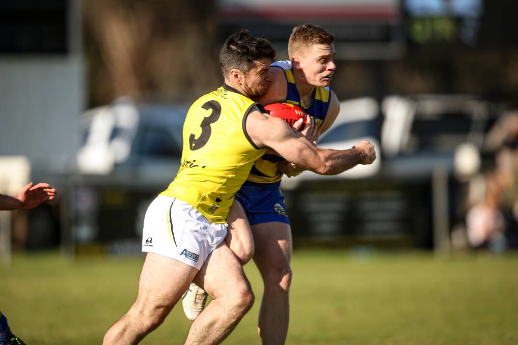 TOUGH DAY AT THE OFFICE: Osborne coach Joel Mackie wraps up MCUE's Alex McCormack in his first game for the Ostriches on Saturday. Mackie's men went down by 25 points. Pictures: JAMES WILTSHIRE